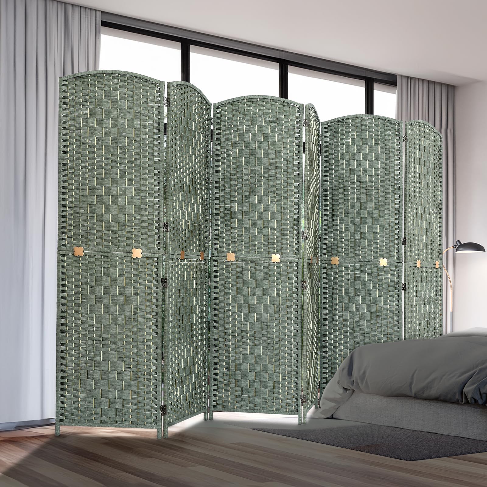 Room divider with six woven panels in natural bamboo and wood, displayed in a bedroom setting near a bed and curtains, offering privacy and style in a green finish.