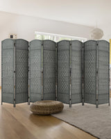 A sleek 8-panel grey bamboo room divider with a woven design stands behind a modern bed, offering privacy and style in a bright, minimalistic bedroom.