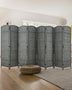 A sleek 8-panel grey bamboo room divider with a woven design stands behind a modern bed, offering privacy and style in a bright, minimalistic bedroom.