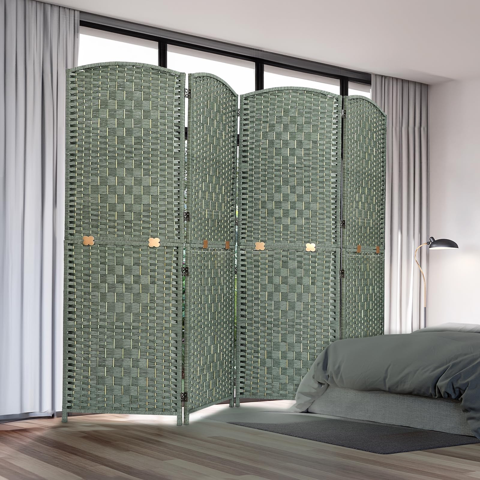 Room divider with four woven panels in natural bamboo and wood, displayed in a bedroom setting near a bed and curtains, offering privacy and style in a green finish.